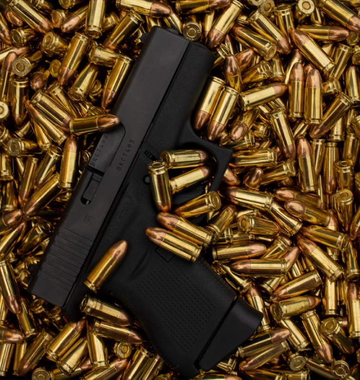 Hand gun laying in a pile of bullets